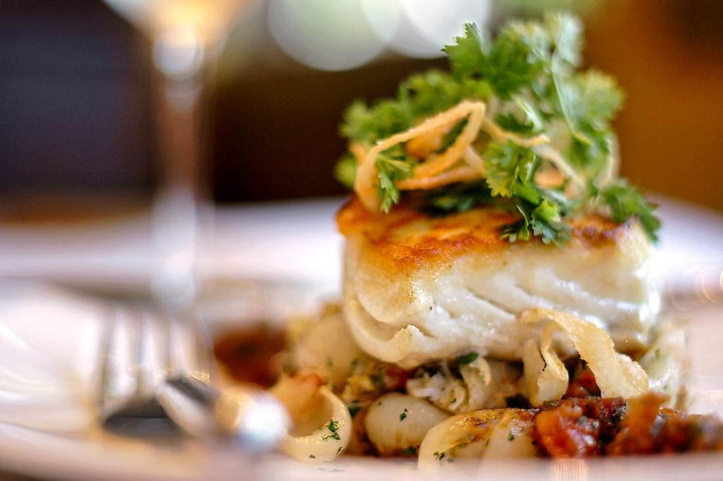 Sea Bass Fillet on a Bed of Oven-Roasted Vegetables with Tomato-Wine Sauce