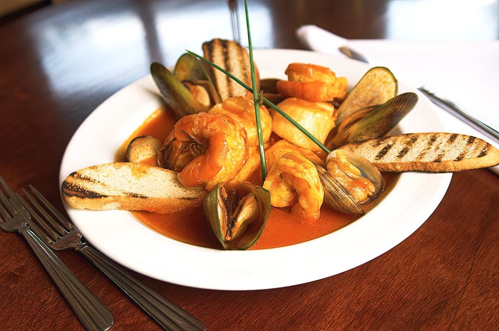 A classic Italian-American seafood stew with a fragrant tomato and wine broth, featuring clams, mussels, and shrimp.